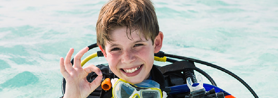 Instructor pointing out marine life to a student underwater.