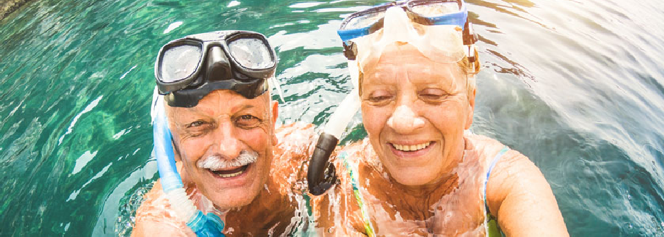 Instructor pointing out marine life to a student underwater.
